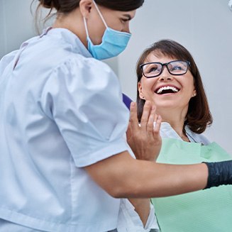 Dentist reviewing X-ray with smiling patient