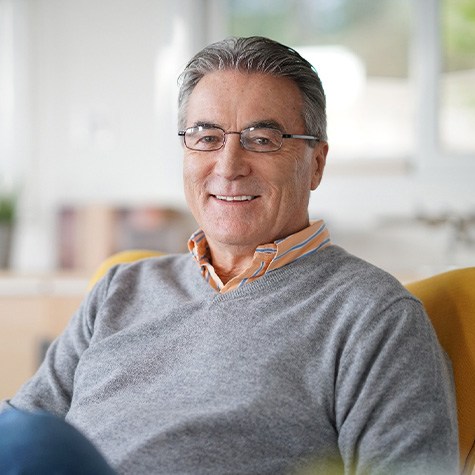 Senior man sitting on couch and smiling