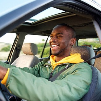 Man smiles while driving