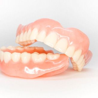 Full set of dentures against neutral background