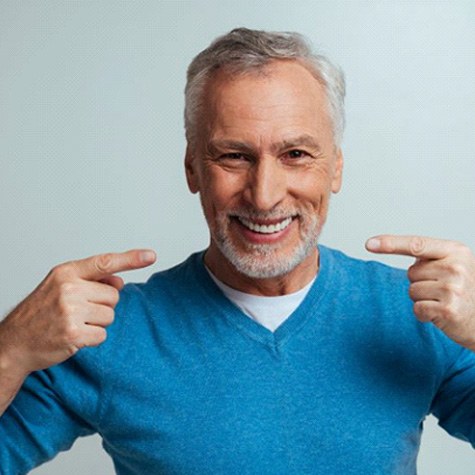 Happy senior man pointing at his smile