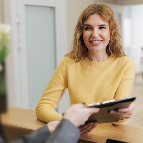 Female patient smiling with paperwork