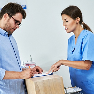 A man paying the cost of his dental treatment
