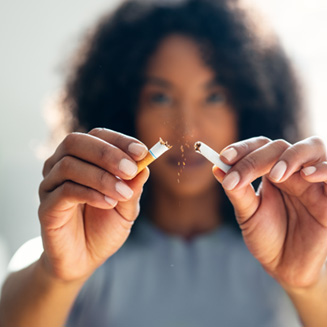 Closeup of woman breaking cigarette